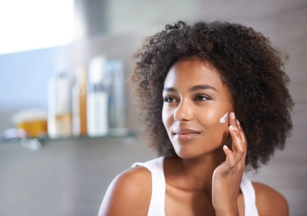 Frau cremt ihr Gesicht ein, Rosazea Therapie, Skincare