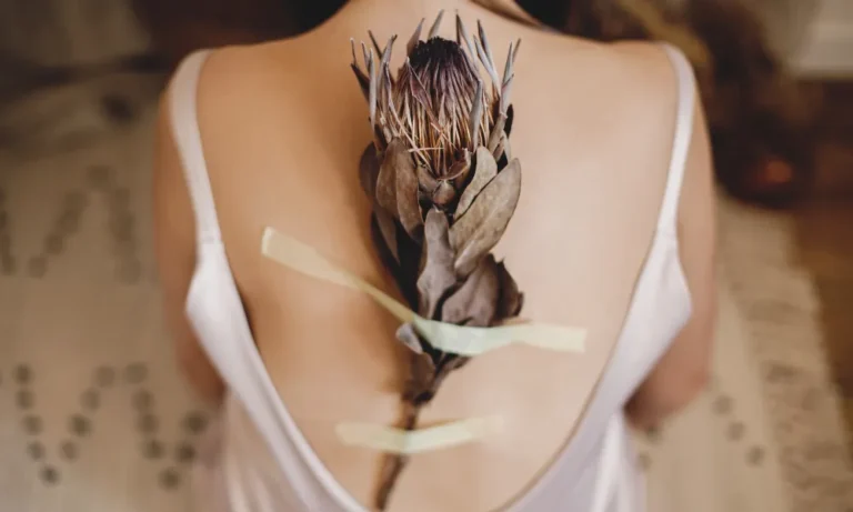 Foto eines Frauenrückens mit einer Königs Protea - Symbolbild zur Schuppenflechte