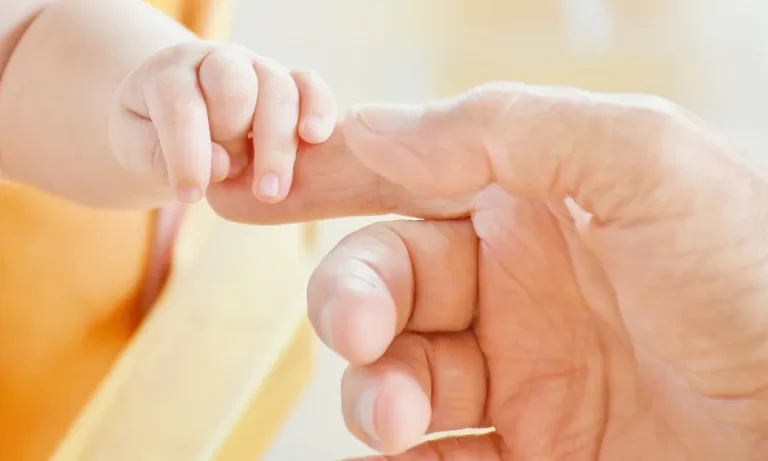 Hand eines Erwachsenen hält Kinderhand