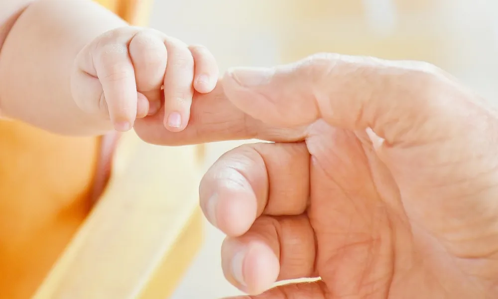 Hand eines Erwachsenen hält Kinderhand